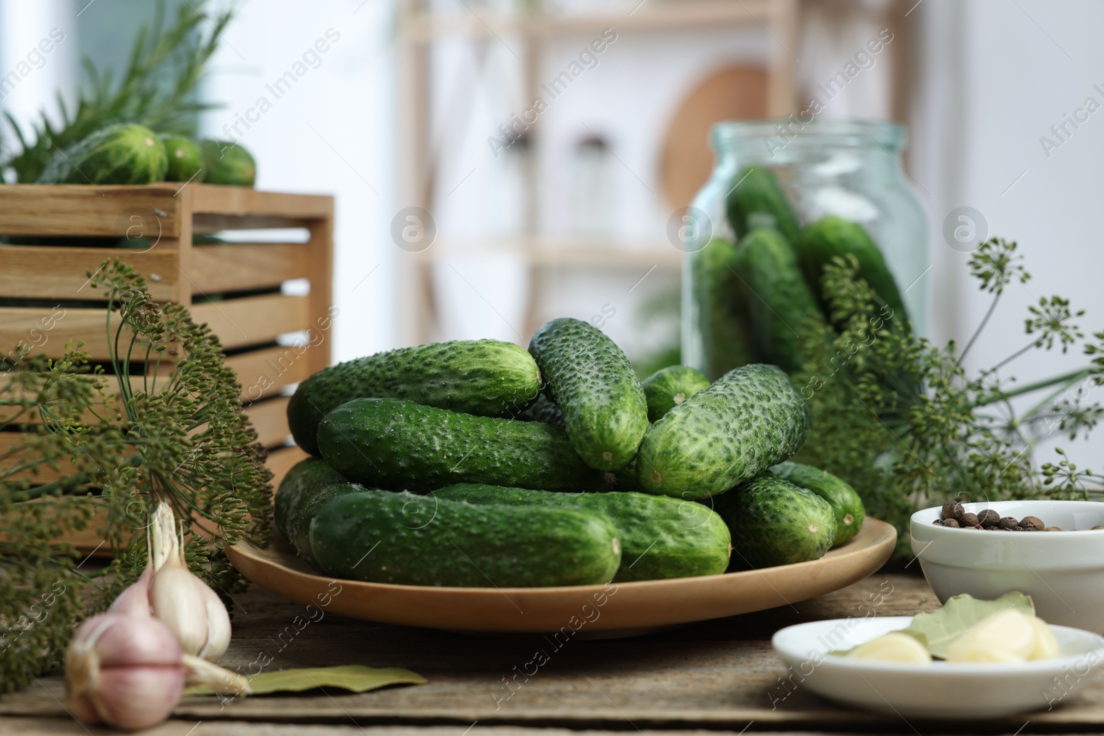 Photo of Fresh cucumbers, dill and spices on wooden table, closeup. Preparation for pickling