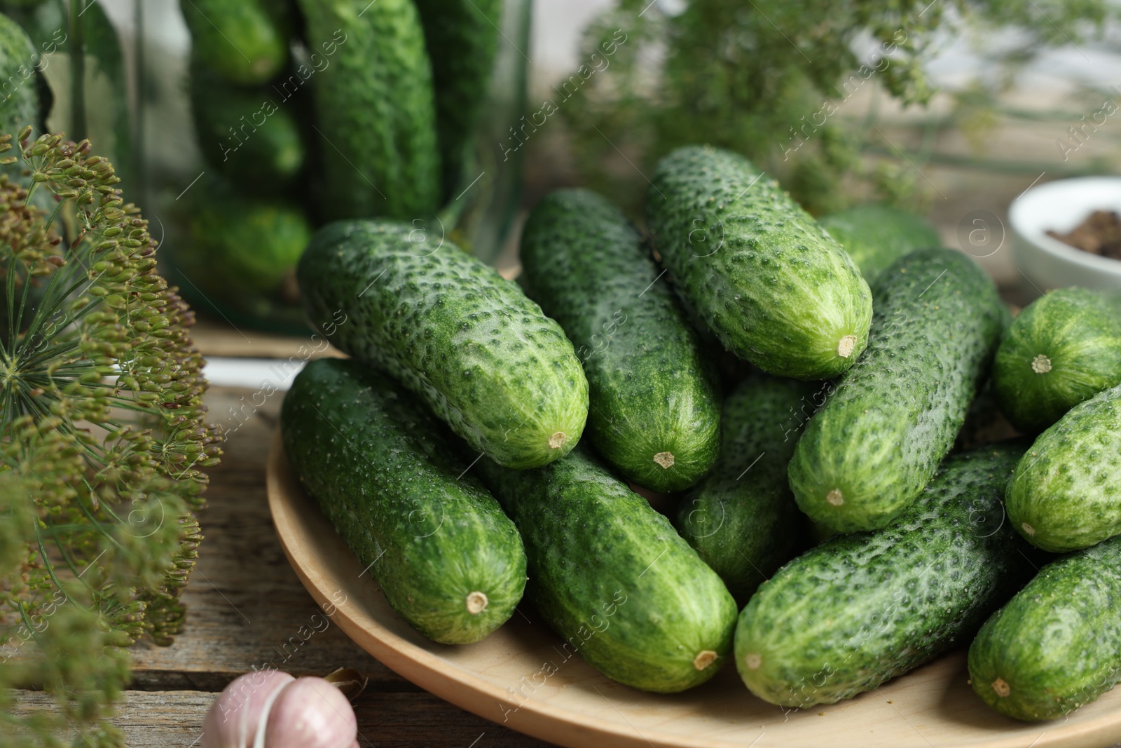 Photo of Fresh cucumbers, dill and garlic on wooden table, closeup. Preparation for pickling