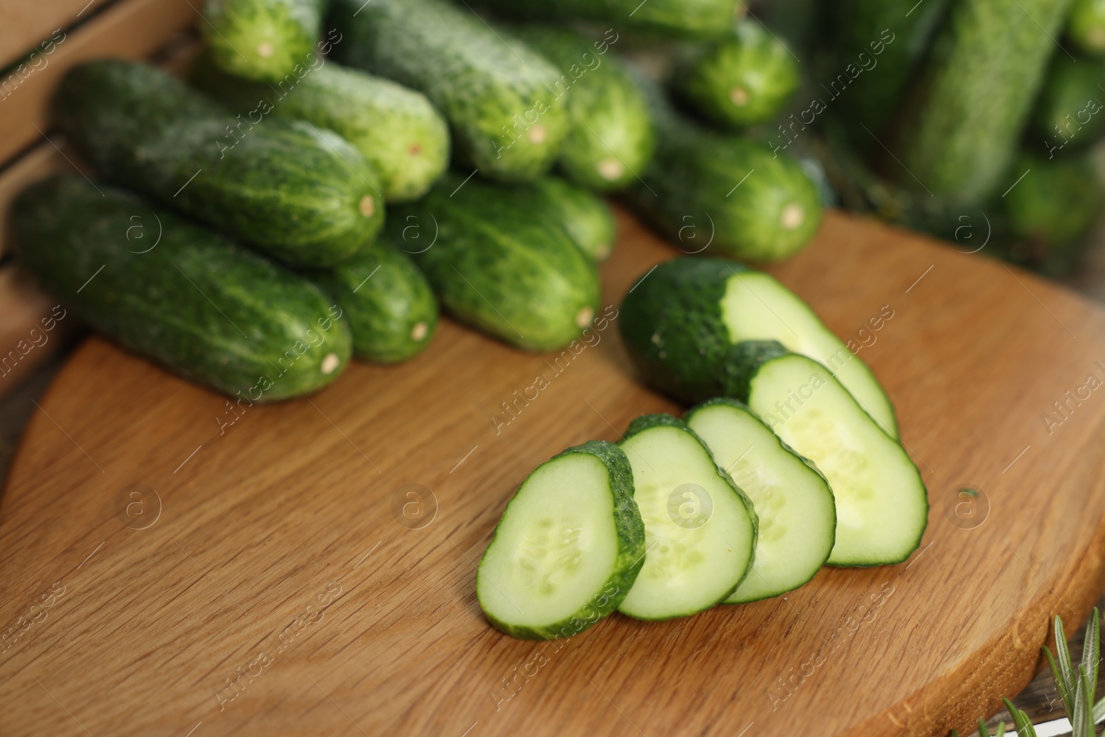 Photo of Fresh cut cucumber on wooden board, closeup