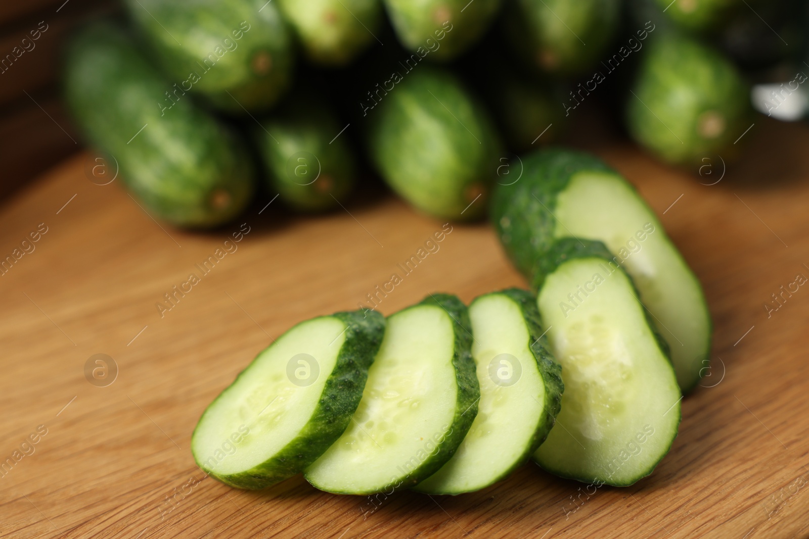 Photo of Fresh cut cucumber on wooden board, closeup