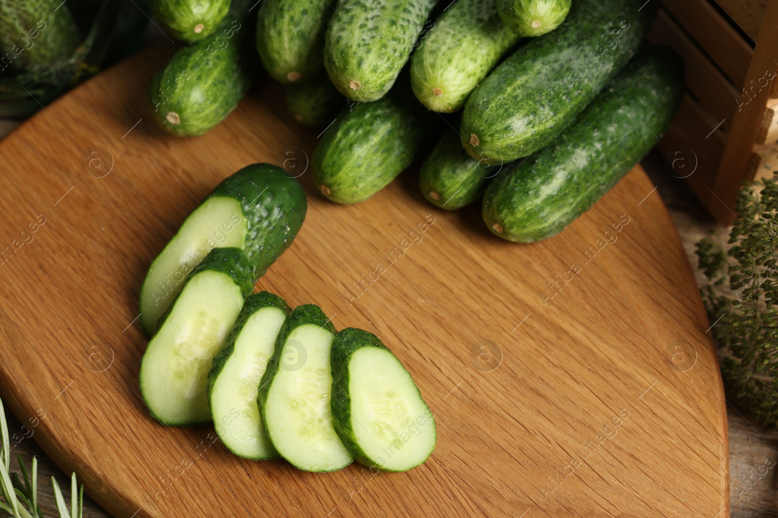 Photo of Fresh whole and cut cucumbers on table