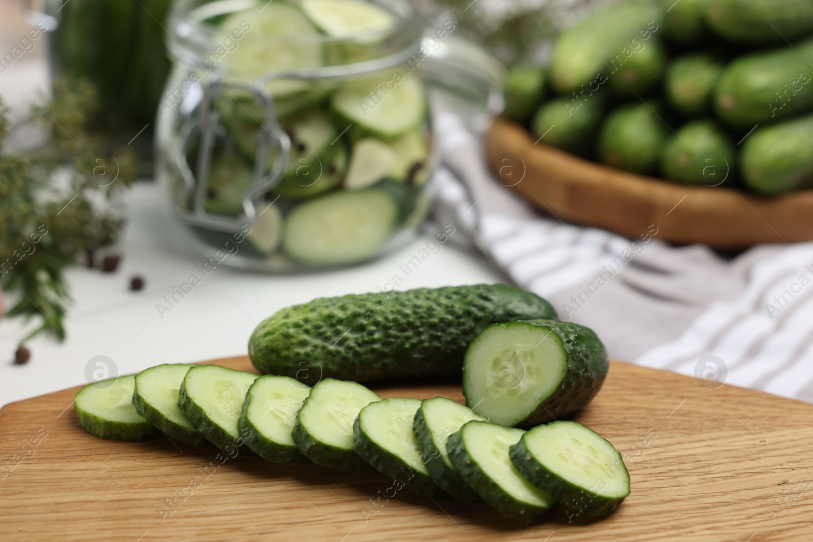 Photo of Board with fresh cut cucumber on table, closeup