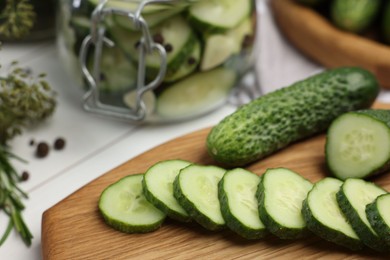 Photo of Board with fresh cut cucumber on light table, closeup. Preparation for pickling