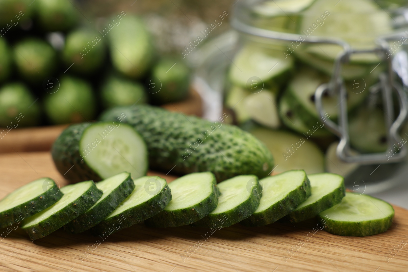 Photo of Board with fresh cut cucumber on table, closeup