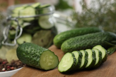 Photo of Board with fresh cut cucumber on blurred background, closeup