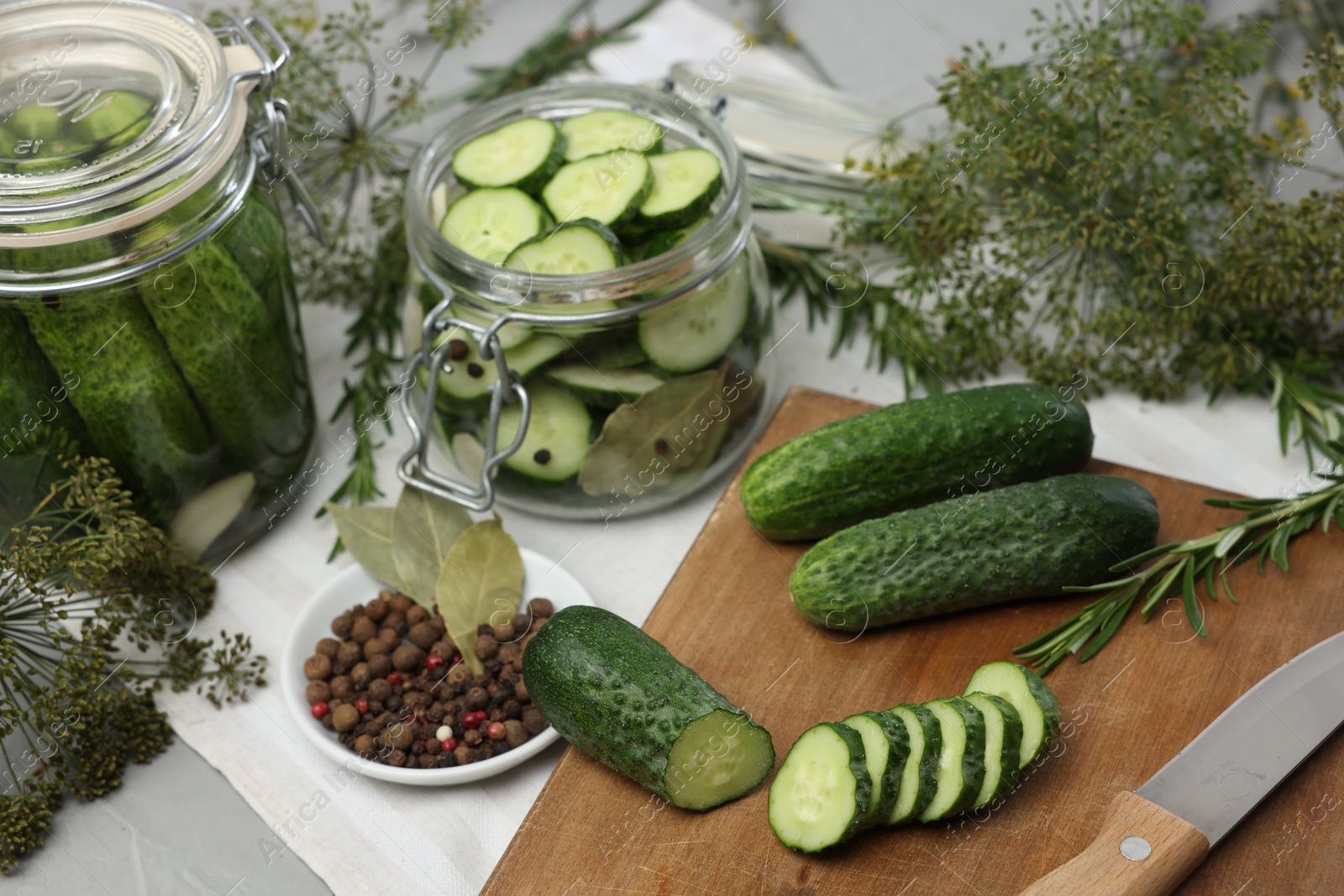 Photo of Fresh cucumbers, dill and spices on light table, closeup. Preparation for pickling