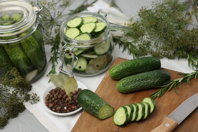 Fresh cucumbers, dill and spices on light table, closeup. Preparation for pickling