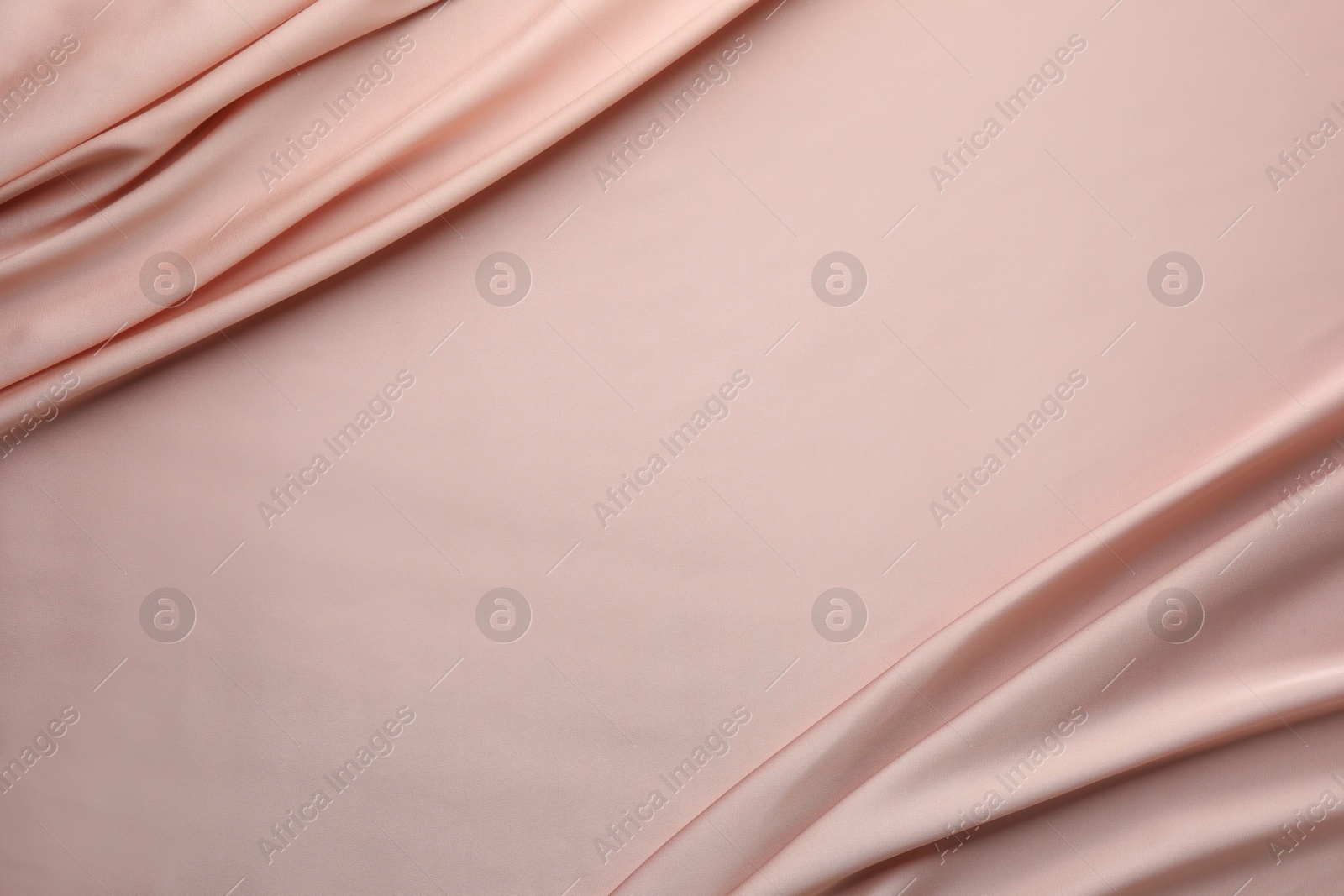 Photo of Crumpled pink silk fabric as background, top view. Space for text