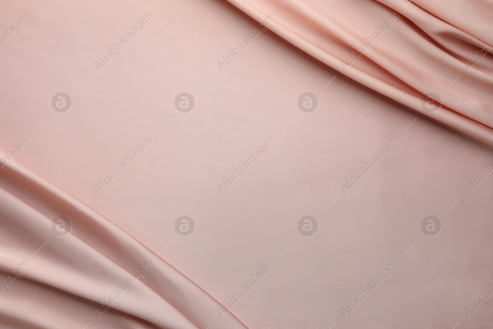 Photo of Crumpled pink silk fabric as background, top view. Space for text