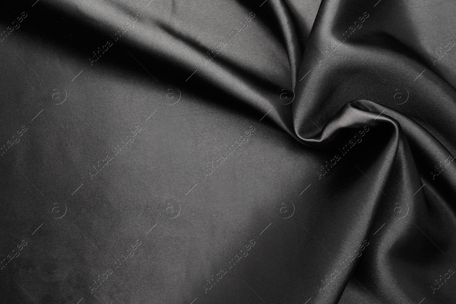 Photo of Crumpled black silk fabric as background, top view. Space for text