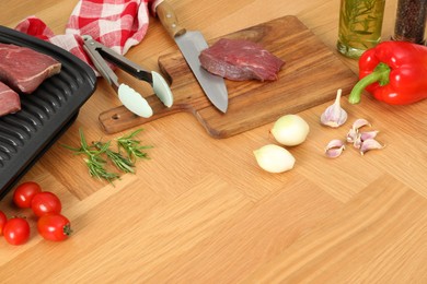 Electric grill and different products on wooden table, above view