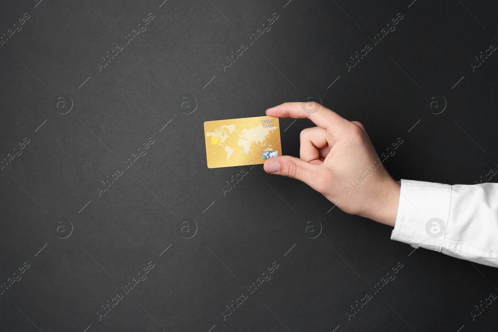 Photo of Man holding credit card on black background, closeup