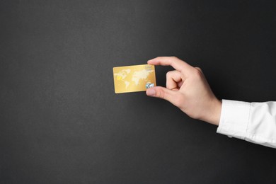 Man holding credit card on black background, closeup