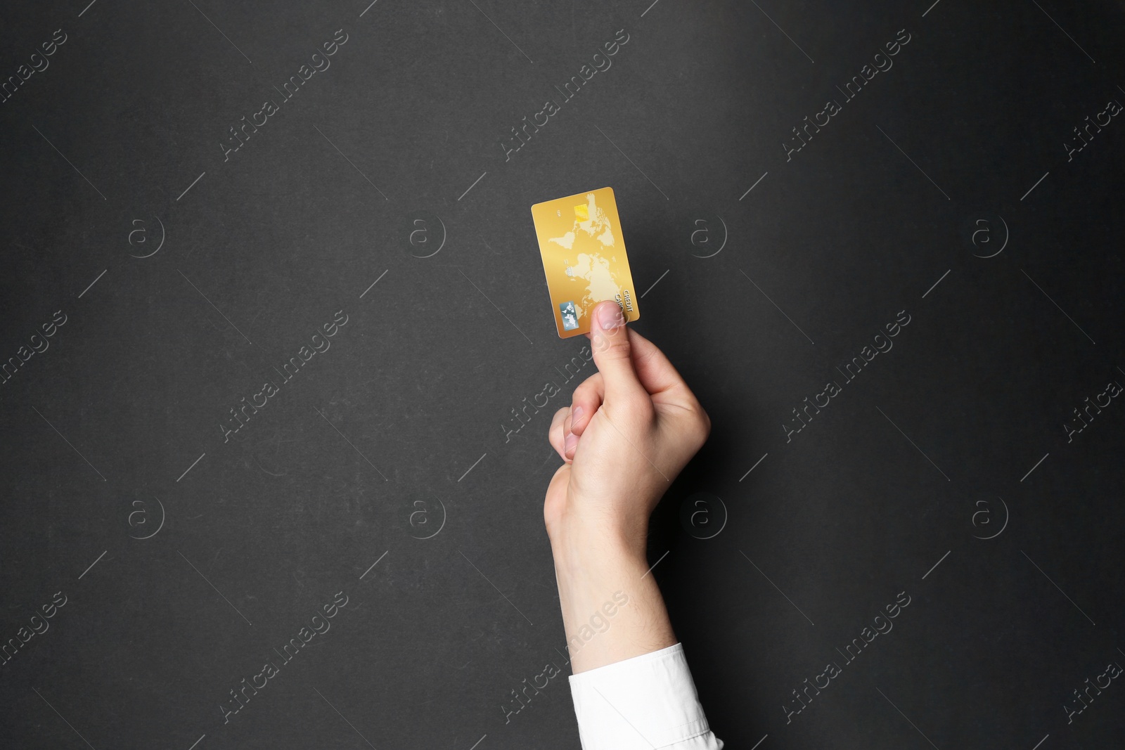 Photo of Man holding credit card on black background, closeup