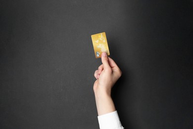 Man holding credit card on black background, closeup