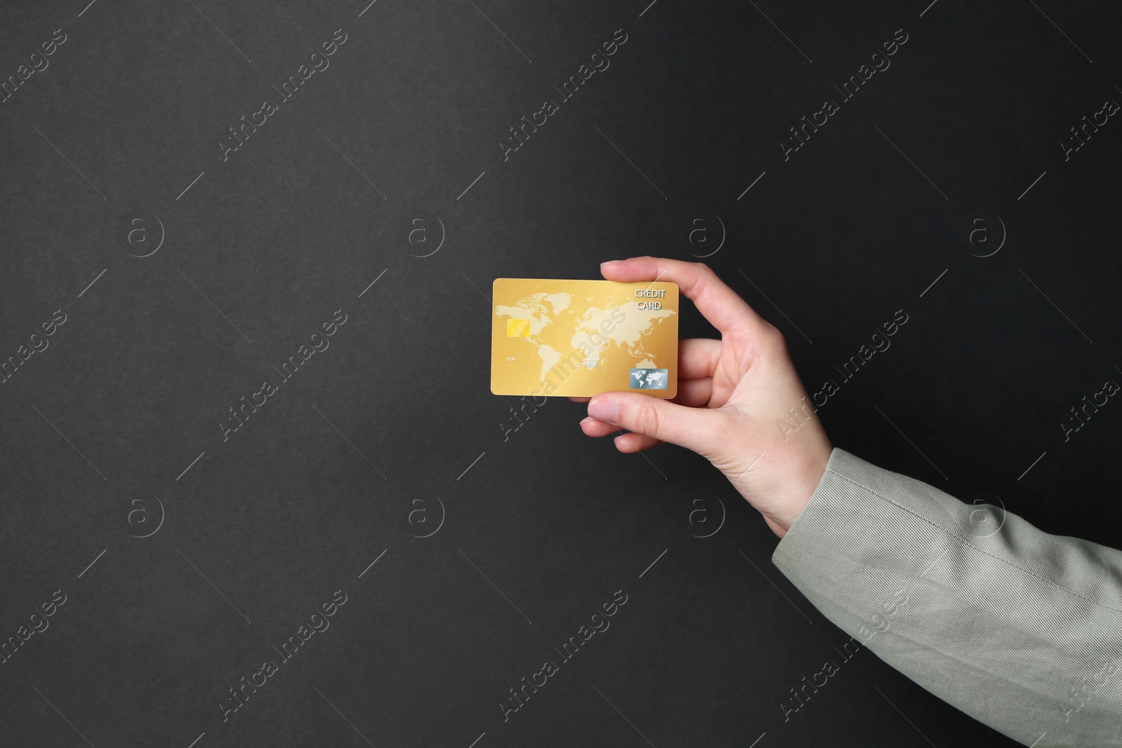 Photo of Woman holding credit card on black background, closeup