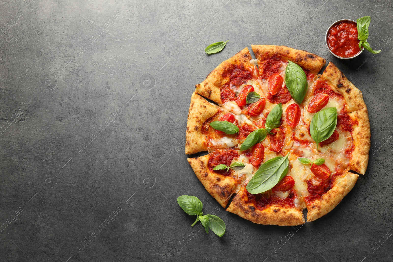 Photo of Delicious Margherita pizza, basil and tomato sauce on grey table, top view. Space for text