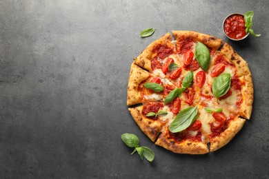 Photo of Delicious Margherita pizza, basil and tomato sauce on grey table, top view. Space for text