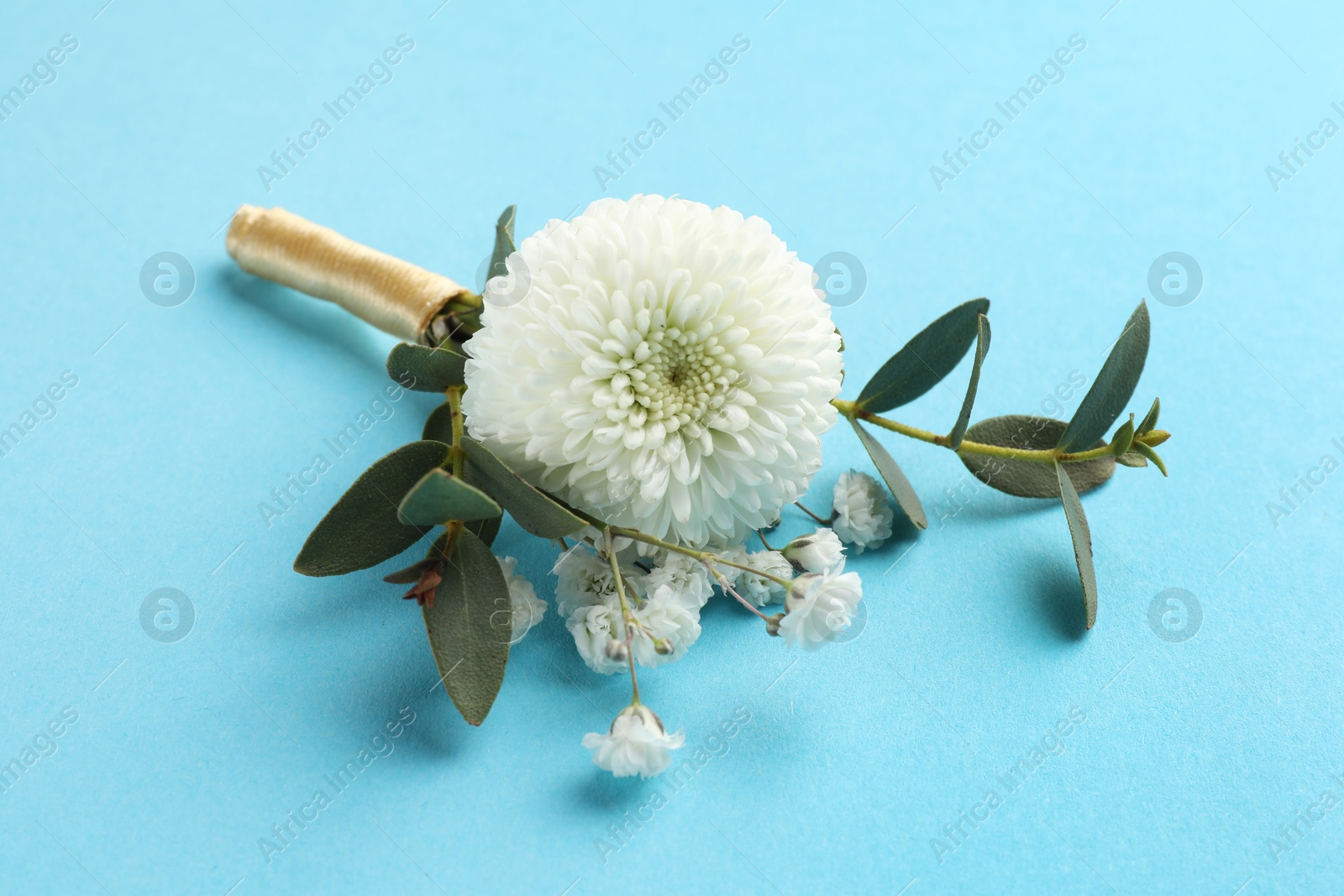 Photo of Small stylish boutonniere on light blue background