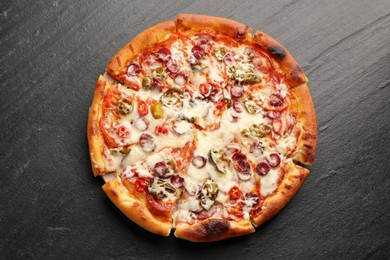 Photo of Delicious pizza Diablo on dark textured table, top view