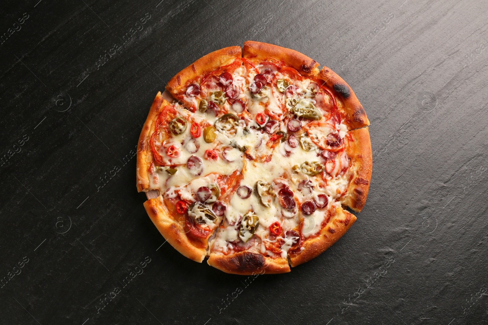 Photo of Delicious pizza Diablo on dark textured table, top view