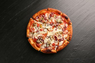 Photo of Delicious pizza Diablo on dark textured table, top view