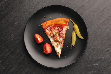 Photo of Plate with delicious pizza Diablo, pepper, tomato and peppercorns on dark textured table, top view