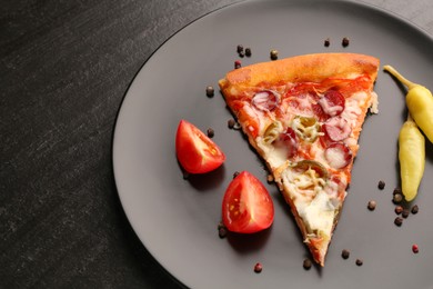 Photo of Plate with delicious pizza Diablo, pepper, tomato and peppercorns on dark textured table, closeup. Space for text