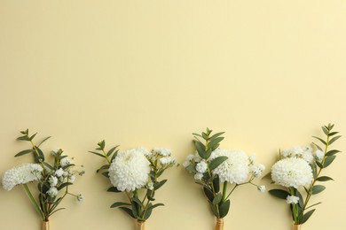 Many stylish boutonnieres on beige background, flat lay. Space for text