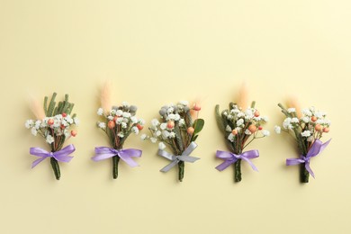 Many stylish boutonnieres on beige background, flat lay. Space for text