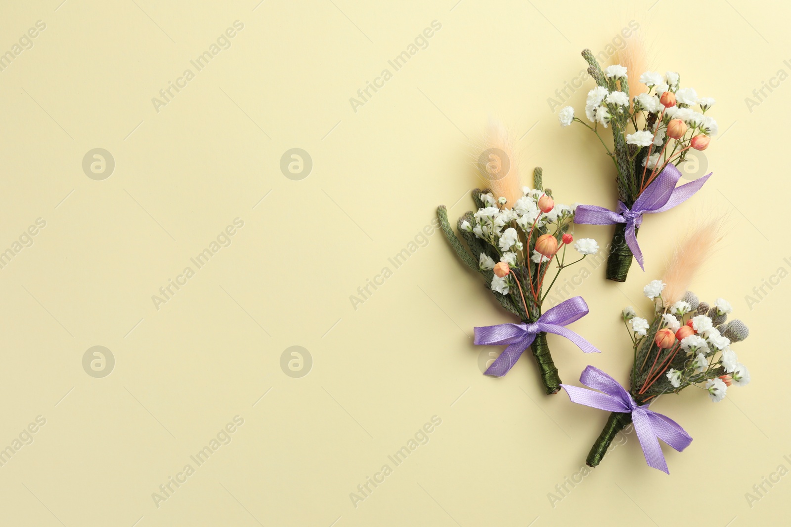 Photo of Many stylish boutonnieres on beige background, flat lay. Space for text