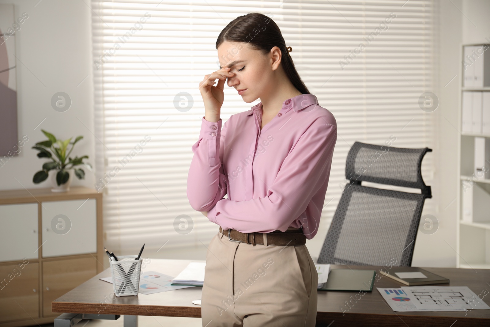 Photo of Embarrassed woman near wooden table in office