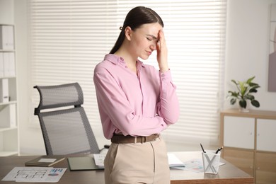 Photo of Embarrassed woman near wooden table in office
