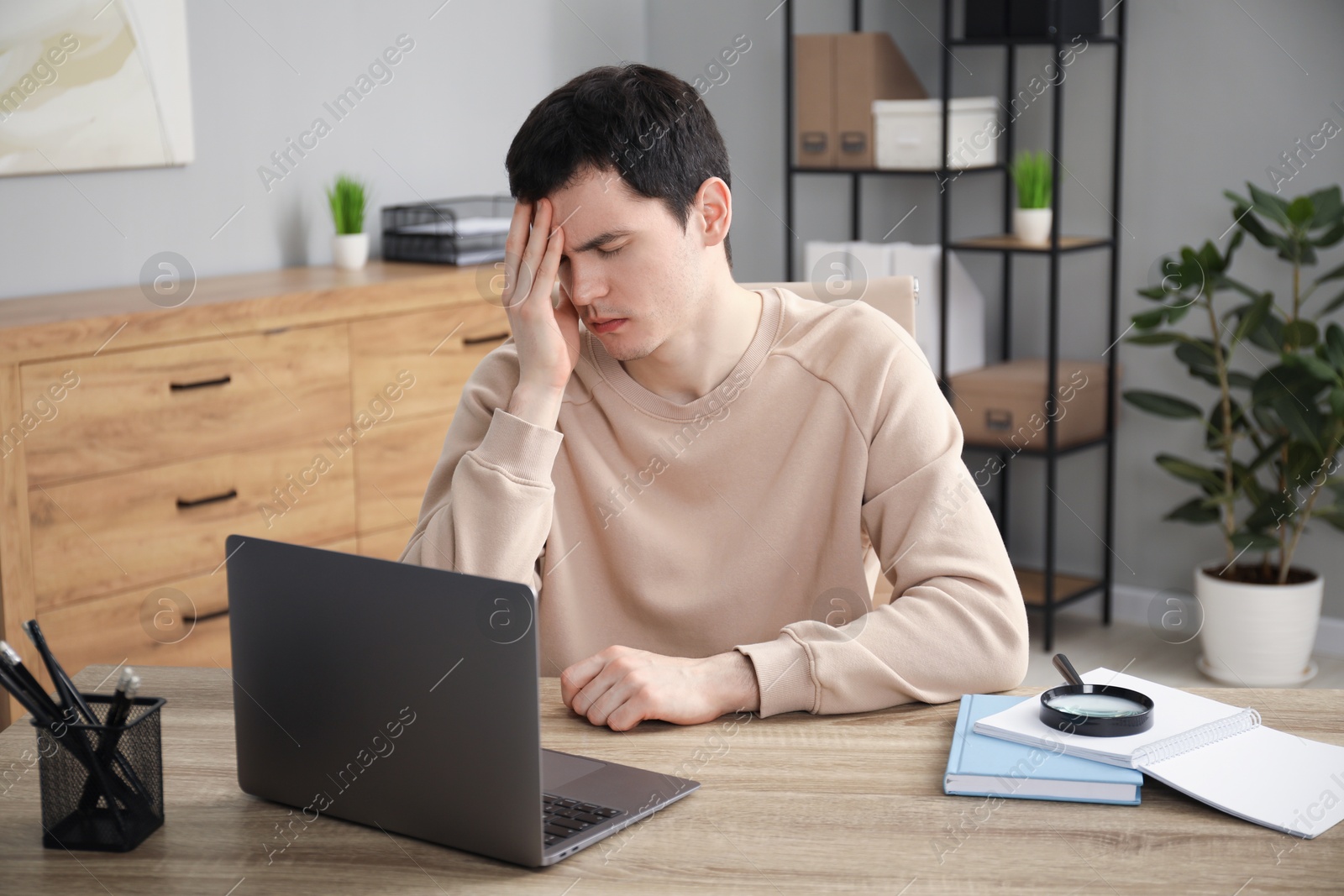 Photo of Embarrassed man at wooden table with laptop in office