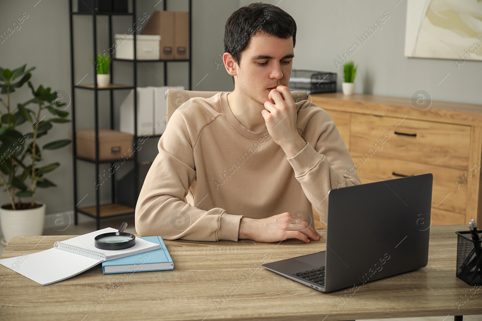 Photo of Embarrassed man at wooden table with laptop in office