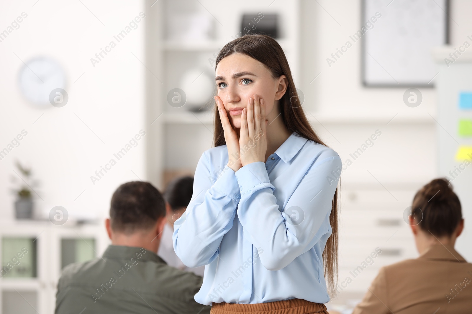 Photo of Woman feeling embarrassed during business meeting in office