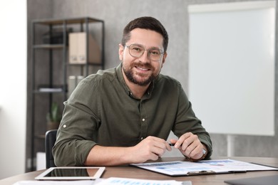 Photo of Consultant with pen at table in office