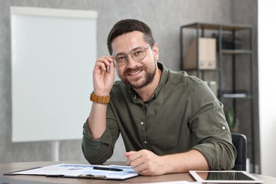 Photo of Consultant in glasses at table in office