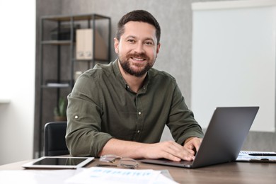 Photo of Consultant working with laptop at table in office