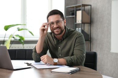 Photo of Consultant in glasses at table in office