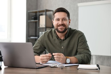 Photo of Consultant at table with laptop in office