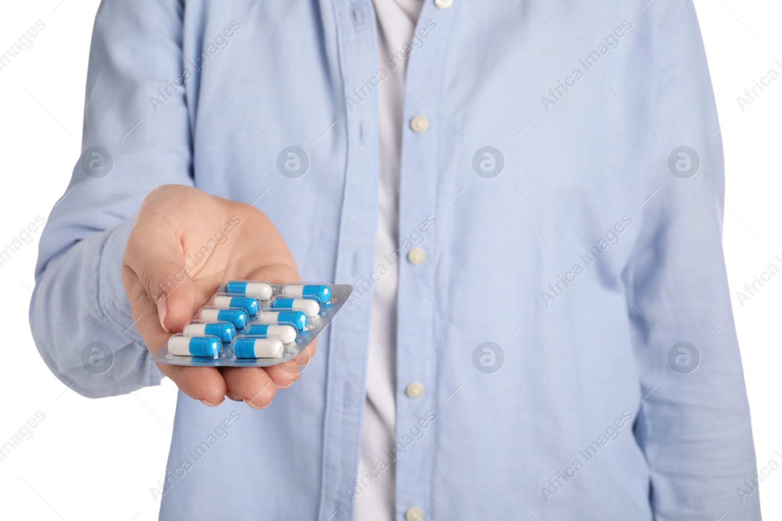 Photo of Woman holding blister with antibiotic pills on white background, closeup