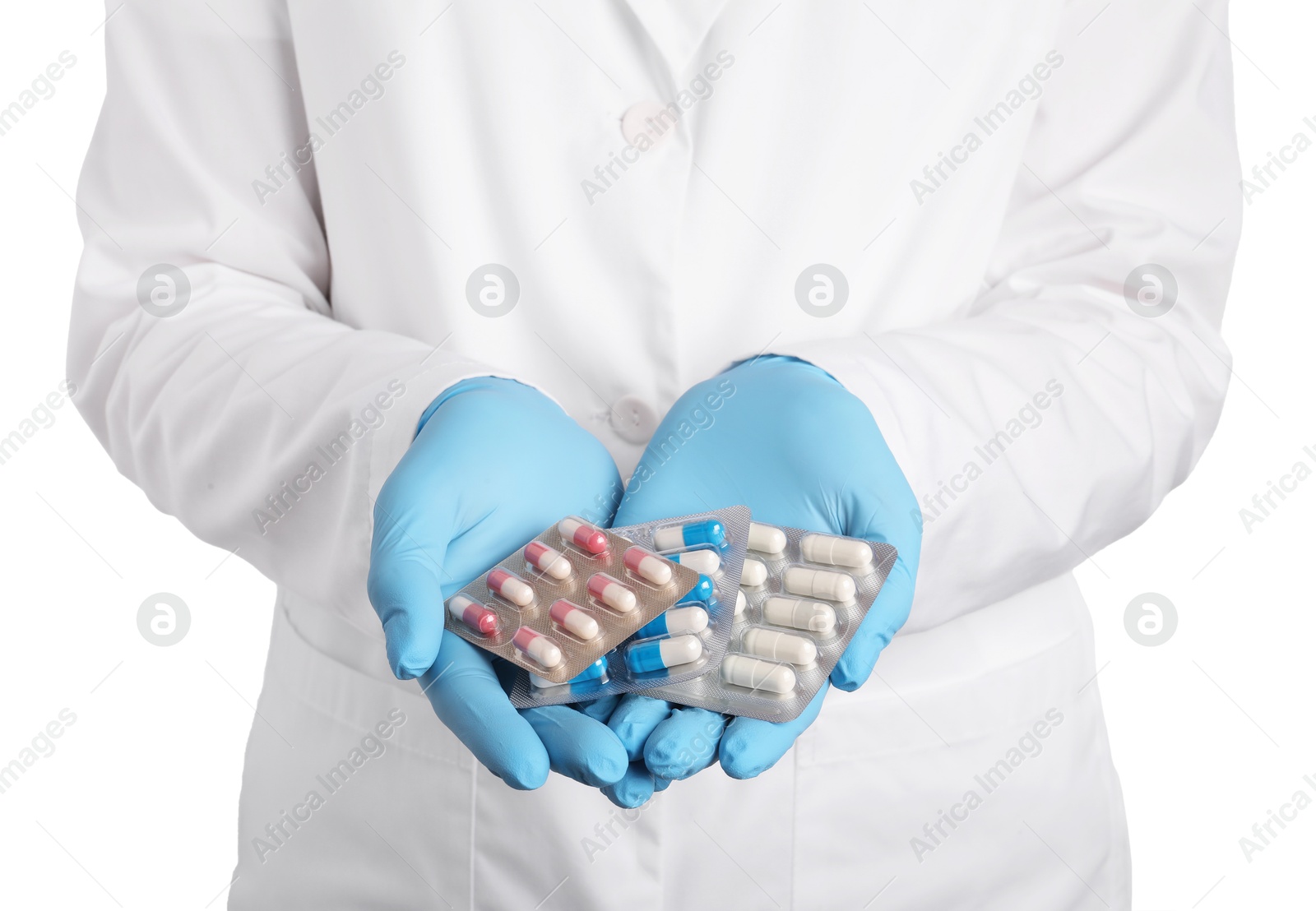 Photo of Doctor holding blister with antibiotic pills on white background, closeup