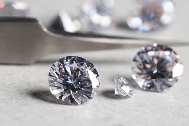 Many beautiful shiny diamonds on light background, closeup