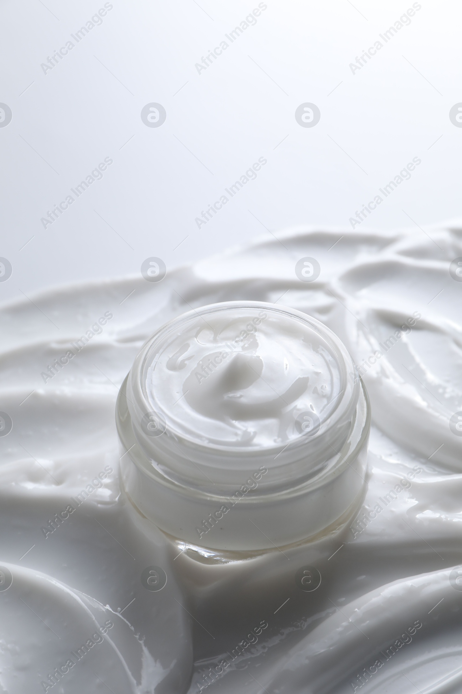 Photo of Face cream in jar on cosmetic product, closeup