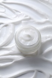 Face cream in jar on cosmetic product, above view