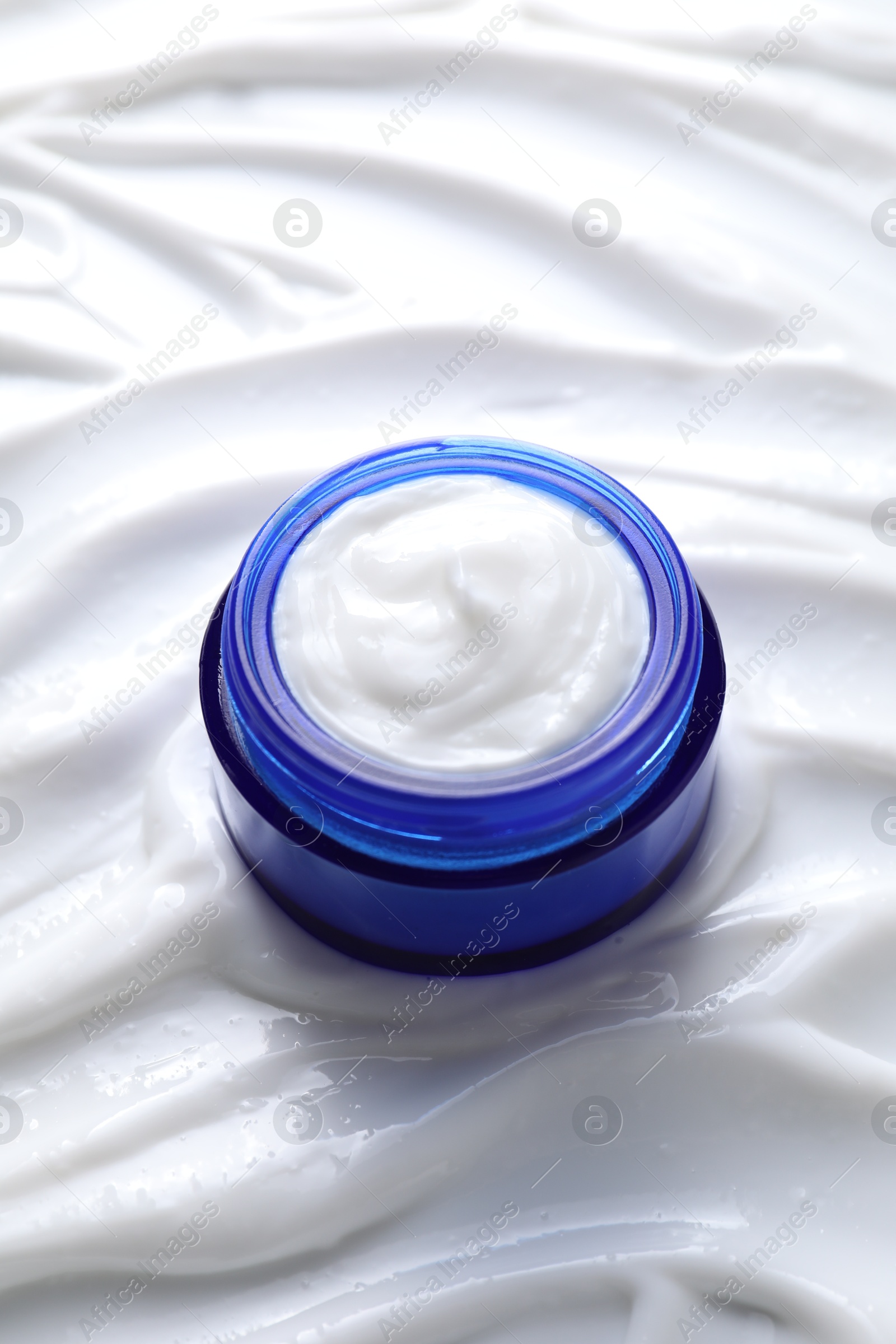 Photo of Face cream in jar on cosmetic product, closeup