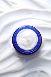 Face cream in jar on cosmetic product, top view