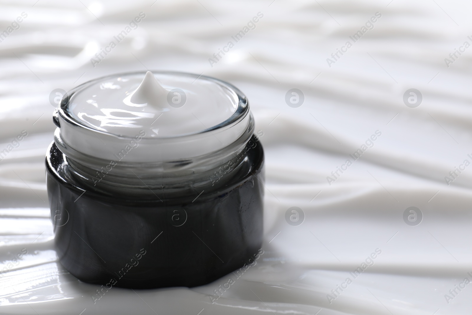 Photo of Jar with face cream, closeup. Space for text