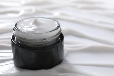 Photo of Jar with face cream, closeup. Space for text